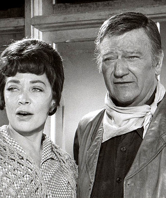 Marie Windsor as Hetty Green and John Wayne as Cahill in Cahill, U.S. Marshal (1973)