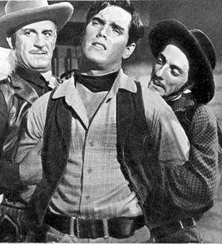 Jeffrey Hunter as Johnny Colt in the hand of two of Apache Joe's men, including (right) Aaron Spelling as Catur in Three Young Texans (1954)