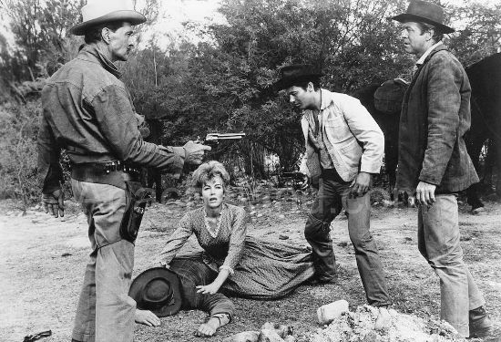 Johnny Barnes (Kent Taylor) and Gil Shepard (Gene Nelson) inch toward a showdown as Amy Carter (Joanna Barnes) and Martin Beaumont (Jerry Summers) check on a downed deputy in The Purple Hills (1961)