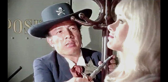 Tun Tun as Oscar the Mooch wants Margie Jones (Sabrina) to tell him why there's so little money in the bank at Yucca Flats in The Phantom Gunslinger (1970)