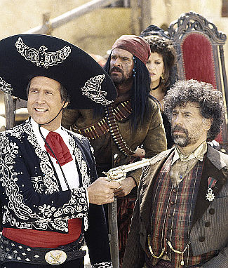 Chevy Chase as Dusty Bottoms with El Guapo (Alfonso Arua) under his gun in Three Amigos (1986)