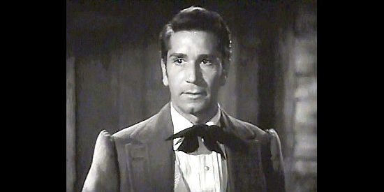 Richard Conte as Dr. Alexander Meade, suspicious of Big Jack's arrival in Monteville in Big Jack (1949)