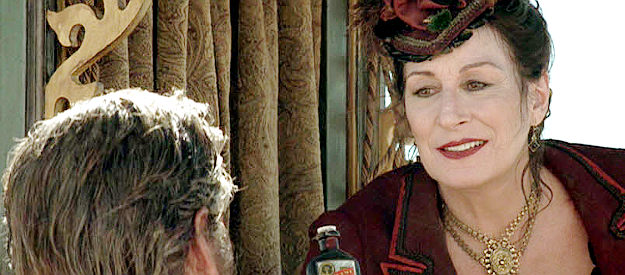 Angelica Huston as Madame Louise Fair, offering trades in the middle of the desert in Seraphim Falls (2006)