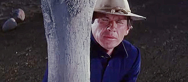 Charles Bronson as Trooper Hanna, spying on Lt. McQuade and Tracey Hamilton in A Thunder of Drums (1961)