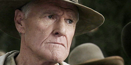 Charles Napier as Sheriff Sanders, investing the sudden death of a preacher in Shadowheart (2009)