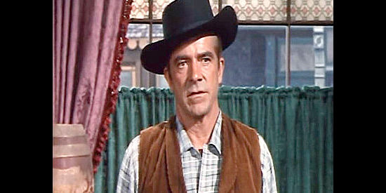 Dana Andrews as Tom Rosser, headed to Montana to tame a town without a badge on his chest in Town Tamer (1965)