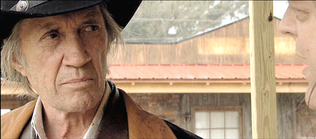 David Carradine as U.S. Marshal Ian McHenry, trying to stop an outlaw gang without much success in All Hell Broke Loose (2009)