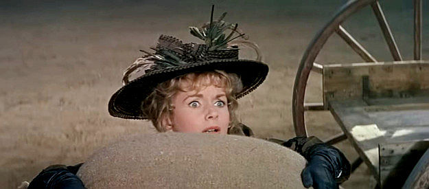 Debbie Reynolds as Lu Rogers, trying to wrestle a large sack of gain into a wagon in The Second Time Around (1961)