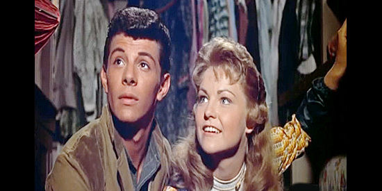 Frankie Avalon as Bert Harvey stealing a hidden moment behind a store counter with Jane Peterson (Alana Ladd) in Guns of the Timberland (1960)