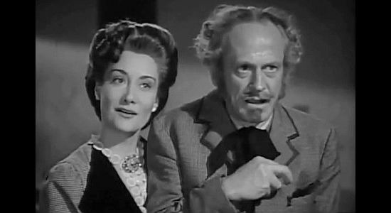 Gloria Holden as Mrs. Thorne, on the way to seek medical attention for husband James (Miles Mander) in Apache Trail (1942)