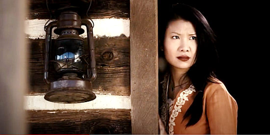 Gwendoline Yeo as Kun Hua, Zhen's wife, wary of the stranger in Heathens and Thieves (2012)