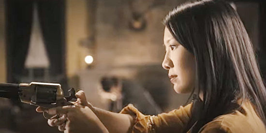 Gwendoline Yeo as Kun Hua, learning to use a six-gun in Heathens and Thieves (2012)