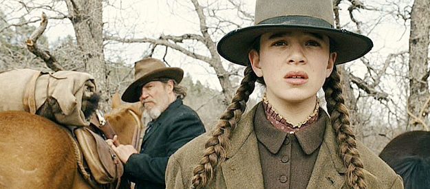 Hailee Steinfield as Matt Ross and Jeff Bridges as Rooster Cogburn, watching LaBoeuf ride off in True Grit (2010)