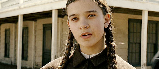 Hailee Steinfield as Mattie Ross, hearing about Marshal Rooster Cogburn for the first time in True Grit (2010)