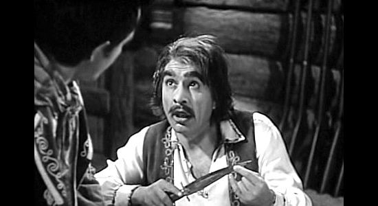 J. Carrol Naish as Three-Fingered Jack, showing off a new knife to one of his men in Robin Hood of El Dorado (1936)
