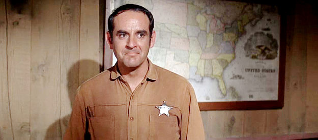 James Almanzar as Sheriff Ramsey, an old friend unsure whether he should welcome Jess Wade back to town in Charro! (1969)