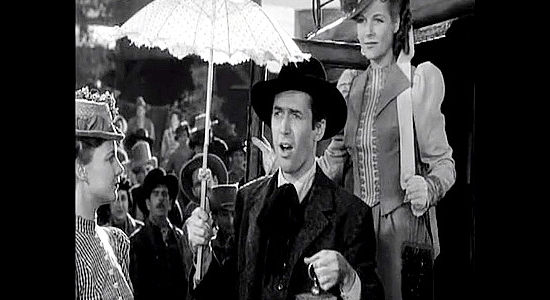 James Stewart as Destry, arriving in Bottleneck carrying a parasol and birdcage for Janice Tyndall (Irene Hervey) in Destry Rides Again (1939)