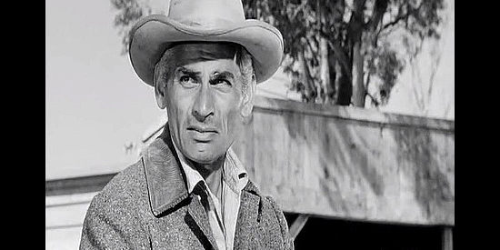 Jeff Chandler as Sam Christy, fearful of the trouble four young bullies can cause in The Plunderers (1960)