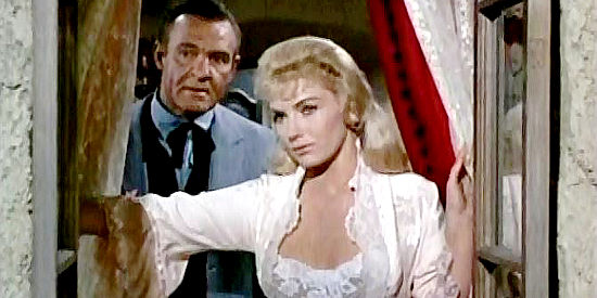 Joan O'Brien as Kelly watching Frank Jesse and Ben Lane ride into town in Six Black Horses (1962)