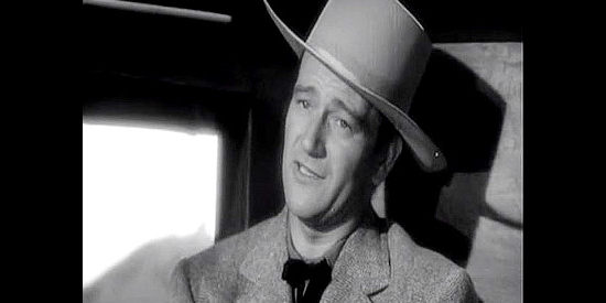 John Wayne as John Devlin, trying to pass himself off as a wheat farmer bound for Dakota in Dakota (1945)