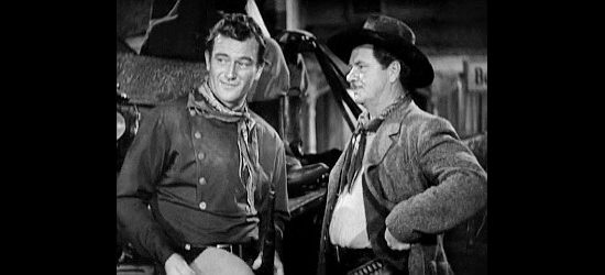 John Wayne as Ringo Kid, determined to make good use of 10 minutes of freedom, granted by Curley (George Bancroft) in Stagecoach (1939)