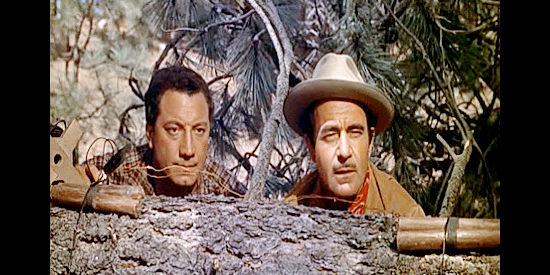 Johnny Seven as Vince and Gilbert Roland as Monty Walker, preparing to blast an opening in their logging road in Guns of the Timberland (1960)