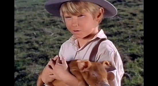 Kelly Corcoran as Christopher 'Kip' Pride, holding his pet pig Anabelle in This Savage Land (1969)