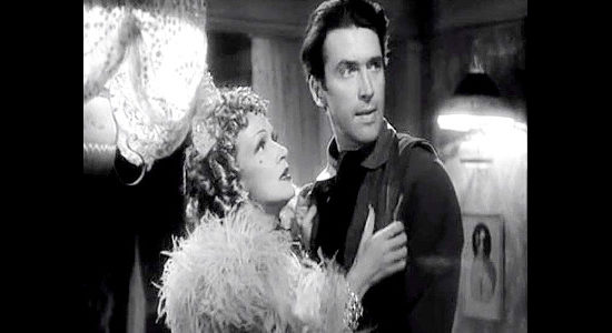 Marlene Dietrich as Frenchy and James Stewart as Destry, reacting to the sound of gunshots in Destry Rides Again (1939)