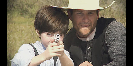 Mason Cook as Connie gets a shooting lesson from Daniel Booko as Spike Kennedy in Wyatt Earp's Revenge (2012)
