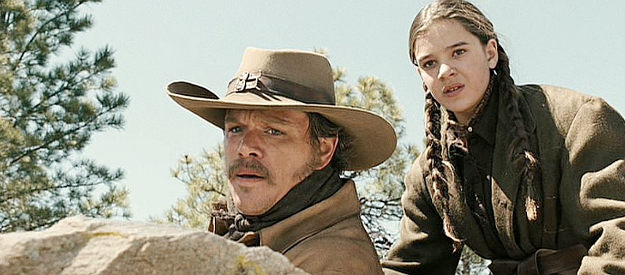 Matt Damon as LaBoeuf and Hailee Steinfield as Mattie Ross, watching Rooster Cogburn ride into trouble in True Grit (2010)