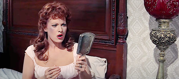 Maureen O'Hara as Katherine McLintock catching a glimpse of the bruise on her face after a fight in McLintock! (1963)