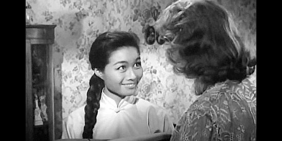 Nobu McCarthy as Kim Sung, making a surprising offer to Madme Lili Raide (Lilyan Chauvin) in Walk Like a Dragon (1960)
