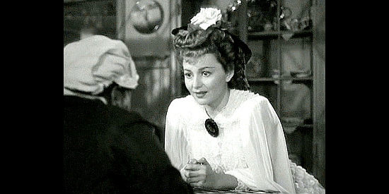 Olivia de Havilland as Elizabeth Bacon, waiting for her maid to read her fortune in They Died with Their Boots On (1941)