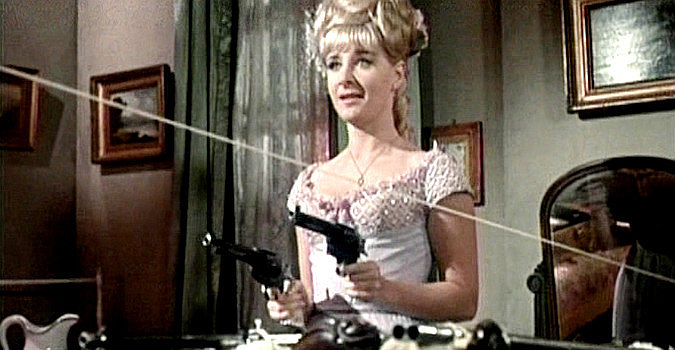 Angela Douglas as Annie Oakley, ready to spring her ambush with two pistols, a rifle and a shotgun in Carry On Cowboy (1966)