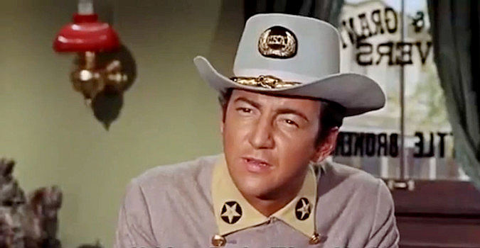 Bobby Darin as Cal Wayne, listening to longtime friend Grant Evers talk about his grand ambitions in Gunfight in Abilene (1967)