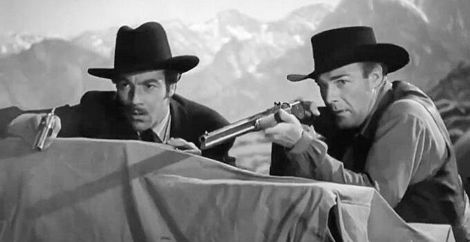 Cesar Romero as Doc Halliday and Randolph Scott as Wyatt Earp, trying to chase off bandits in Frontier Marshal (1939)