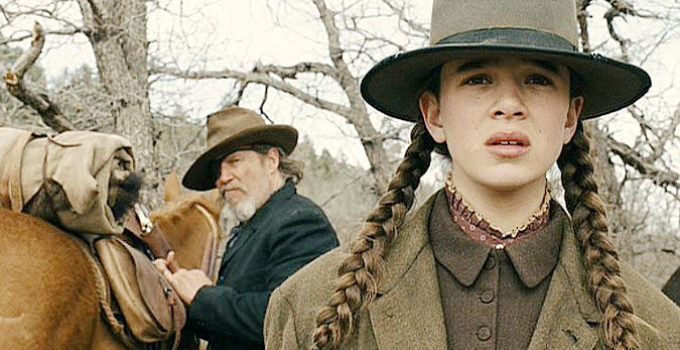 Hailee Steinfield as Matt Ross and Jeff Bridges as Rooster Cogburn, watching LaBoeuf ride off in True Grit (2010)
