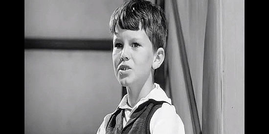 Ray Ferrell as Billy Miller, Kate's son, helping the four young men settle into her hotel in The Plunderers (1960)