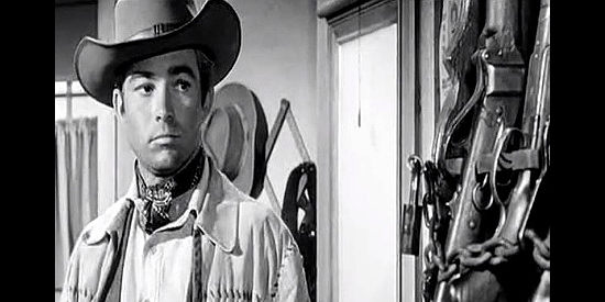 Ray Stricklyn as Jeb Tyler, eyeing the firearms in the sheriff's office in The Plunderers (1960)