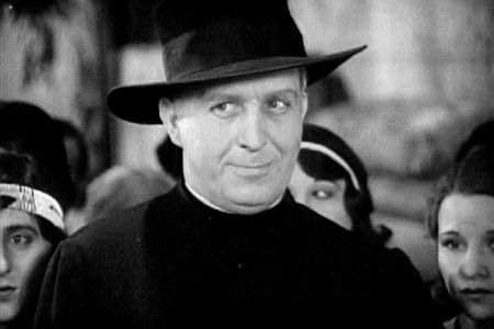 Robert Graves as the priest, wise to the way of Louis La Bey in Men of the North (1930)