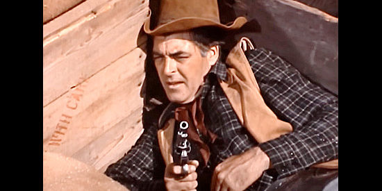 Rory Calhoun as Clint McCoy, taking shelter in a wagon bed during the final showdown in Young Fury (1965)