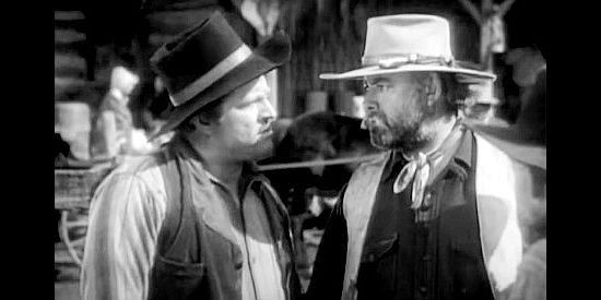 Roy Stewart (right) as Couch, the wagon master, concerned about possible trouble with Indians in Fighting Caravans (1931)