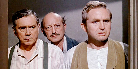 Storekeeper Sam Giller (John Alexander), the hotel clerk and Sheriff Olsen (Karl Swenson) gather after the death of Mitch's wife in One Foot in Hell (1960)