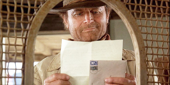 Terence Hill as Doc West, getting a letter from the young girl he's putting through school in Triggerman (2009)