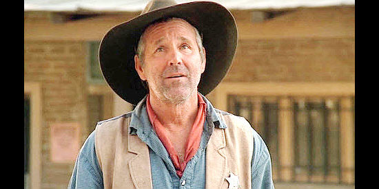 Timothy Bottoms as Gus, the sheriff more committed to serving Stu Croaker than justice in Lone Rider (2008)
