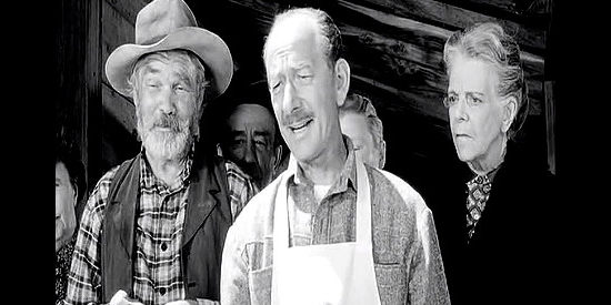 Vaughn Taylor (center) as Jess Walters, Ellie's dad, concerned about an unpaid bill at his general store in The Plunderers (1960)