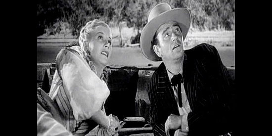 Vera Ralston as Sandy and John Wayne as John Devlin, watching Capt. Bounce lose his temper with river pirates in Dakota (1945)