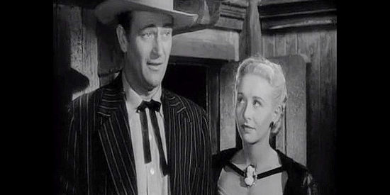 Vera Ralston as Sandy, casting a suspicious gaze in the direction of hubby John Devlin (John Wayne) as he introduces himself to a dance hall girl in Dakota (1945)