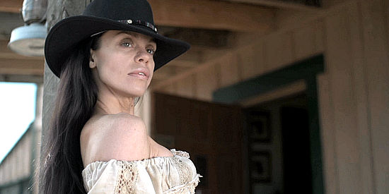 Veronica Diaz as Dulce de la Rosa, watching her lover manipulate the townsfolk in The Gundown (2011)