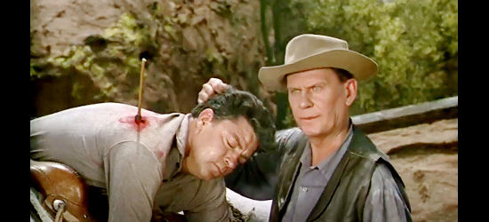 Wendell Corey as Clint Mailer checking out Wade Cooper (Dale Robertson), the wounded man his wife brings home in Blood on the Arrow (1964)